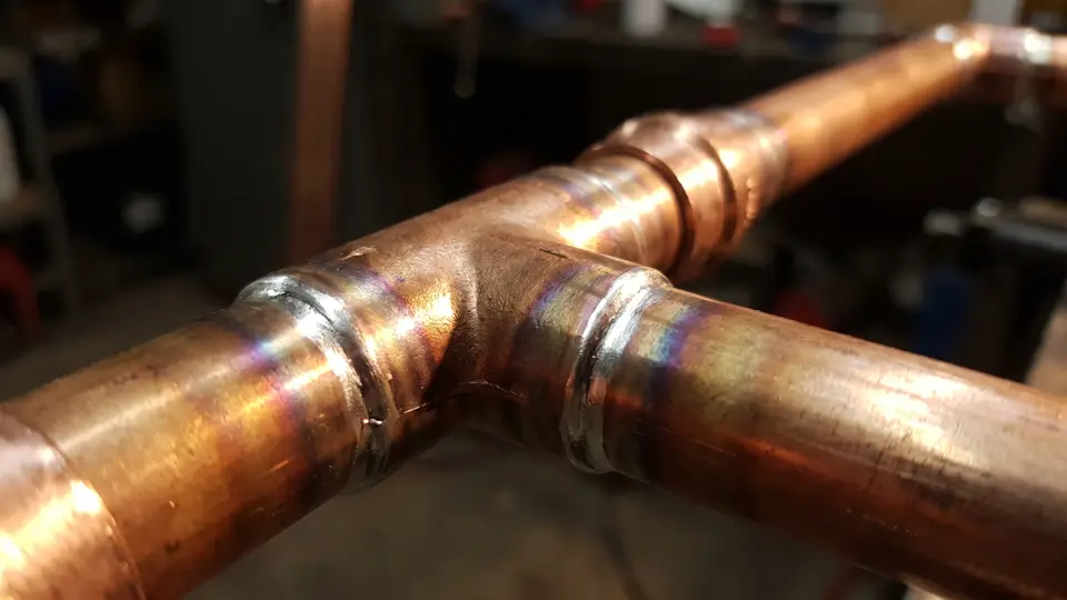 Freshly sweated copper joints, the solder fillets bright and even around each fitting