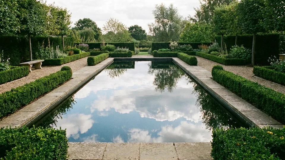 A rectangular reflecting pool with cut stone coping mirroring the sky